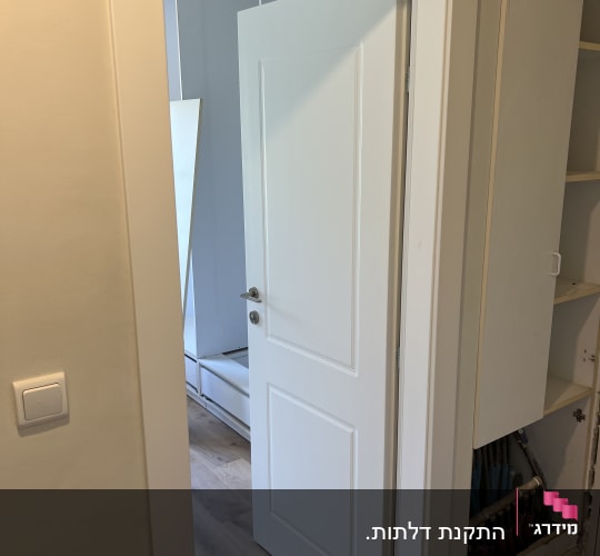 דלת פנים לבנה מעוצבת עם משקוף לבן וידית כסופה